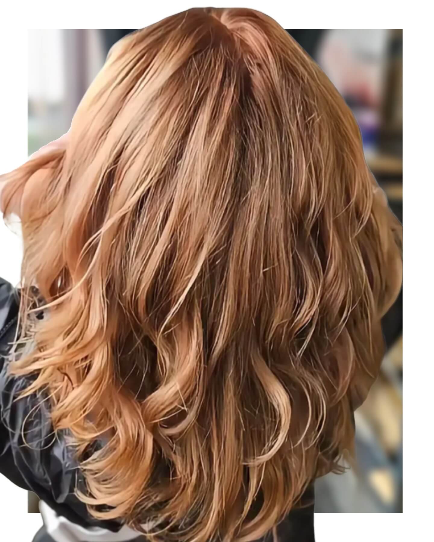 - Indira Salon Spa in Chicago IL, Park Ridge IL, Green Bay WI A person with shoulder-length, wavy, light brown hair is shown from the back, wearing a dark-colored top. - Indira Salon Spa in Chicago IL, Park Ridge IL, Green Bay WI